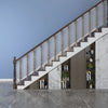 A modern interior featuring a staircase with wooden railings and glass mesh safety barriers against a light gray wall.