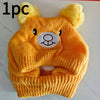 A knitted orange dog ear hat featuring bear ears and a circular embroidered face design.
