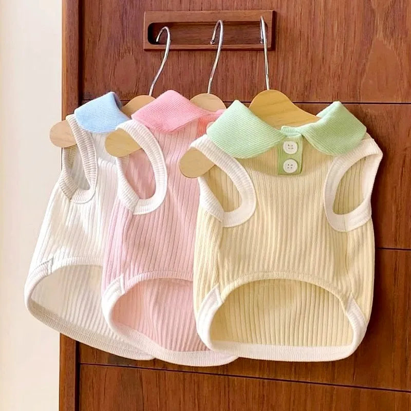 Three pastel-colored cooling pet polo shirts for small dogs and cats hanging on a wooden rack