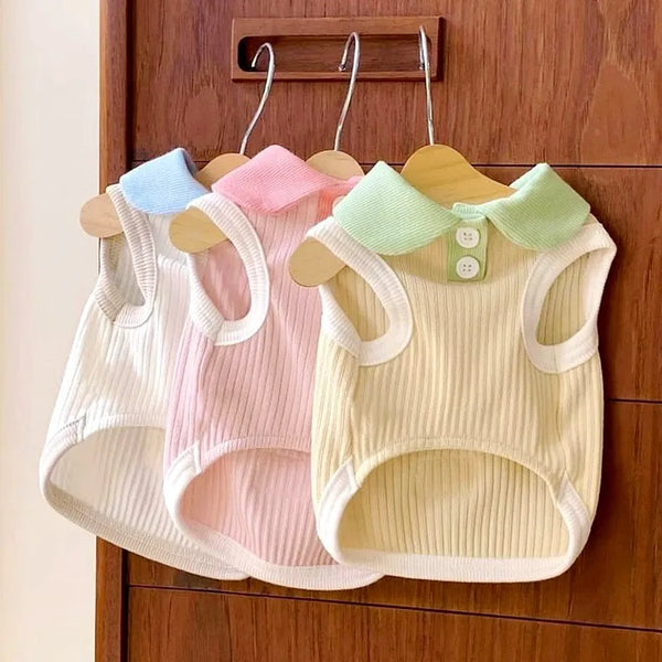 Three pastel-colored cooling pet polo shirts for small dogs and cats hanging on a wooden rack