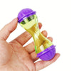 Una mano sostiene una pelota juguete para mascota de alimentador interactiva de plástico morado y transparente.
