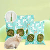 A light brown rabbit sits next to a teal fabric bag filled with green hay, used as a multi-hole hay feeder for small animals.