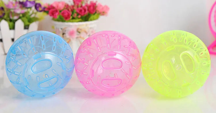 Three transparent plastic exercise balls in blue, pink, and yellow for small pets