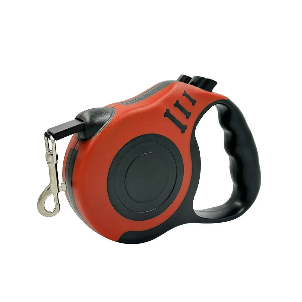 An orange and black automatic retractable dog leash with a black handle and three visible wires.