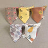 A set of five cotton triangle baby bibs featuring various cartoon prints and colors.