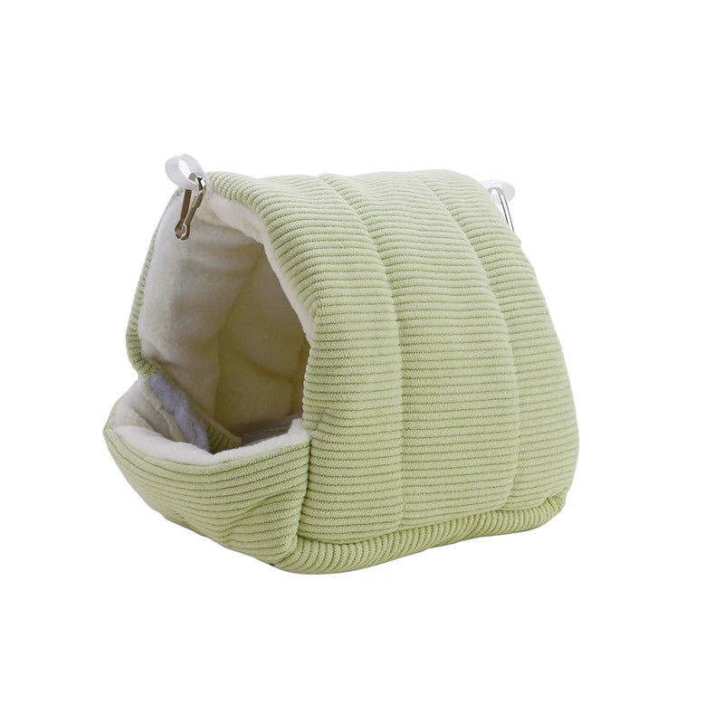 A light green, ribbed cotton bird nest with a soft inner lining and small ear loops.