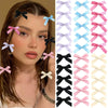 A collection of pink, blue, and white ribbon bow hair clips displayed next to a woman's hair.