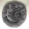 A round, dark gray plush pet bed with a fluffy texture and anti-slip base.