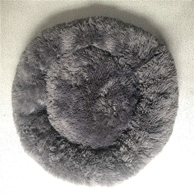 A round, dark gray plush pet bed with a fluffy texture and anti-slip base.
