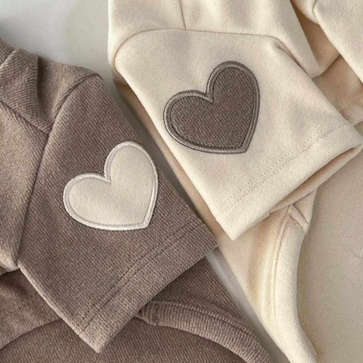 Sudadera de oso acogedora beige para mascotas, mostrada doblada con detalle de corazón.