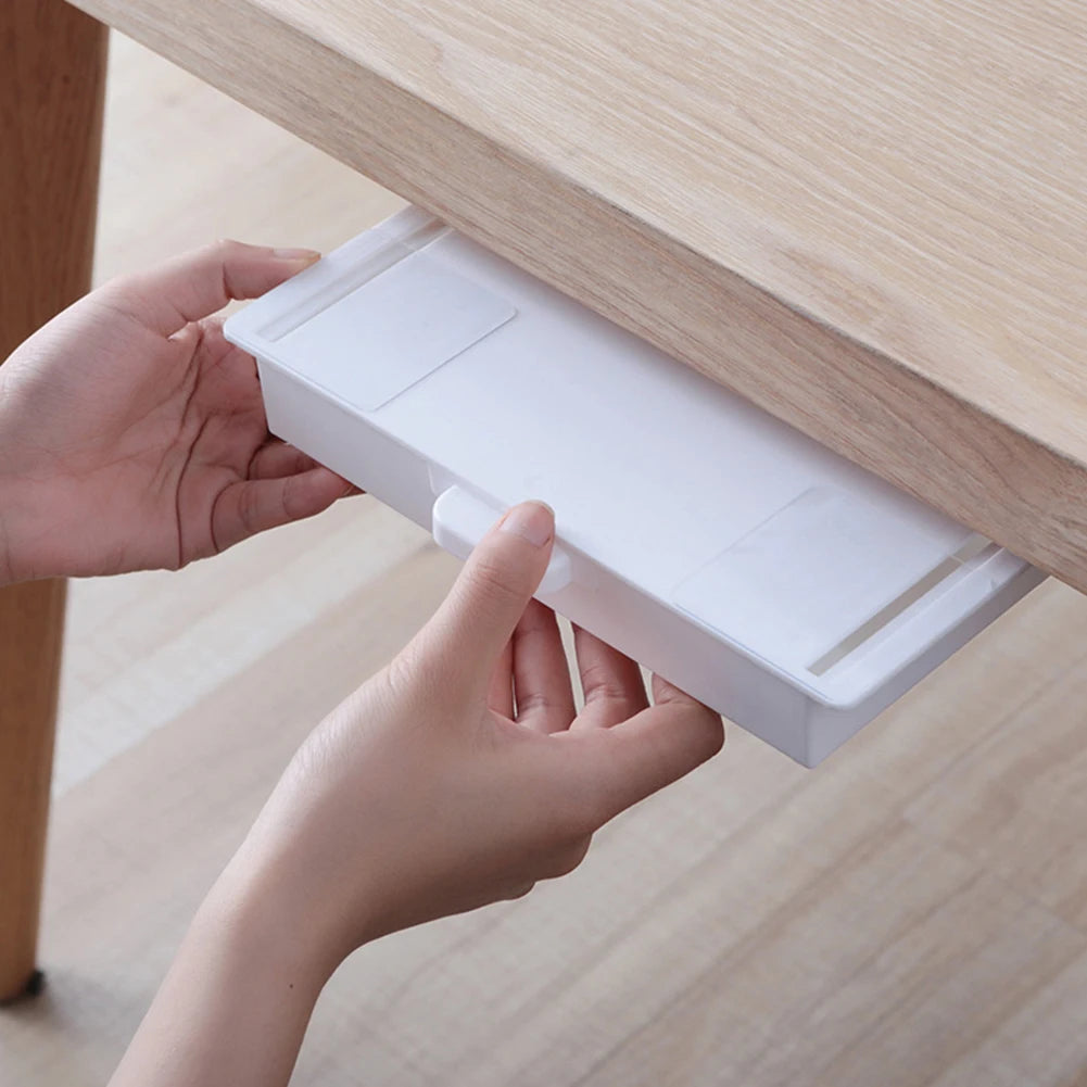 A hand is opening a white dust-proof cover for an under desk drawer organizer.