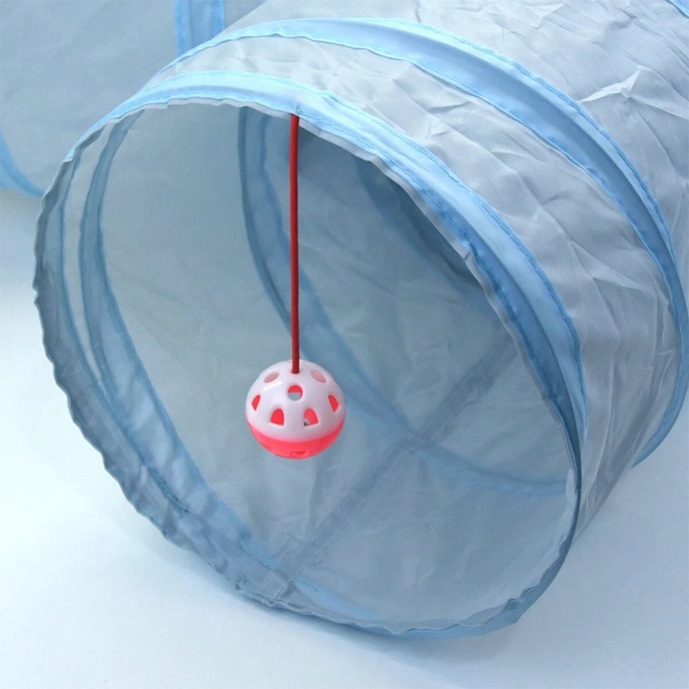 A light blue foldable cat tunnel with a pink ball and a red string visible through the mesh.