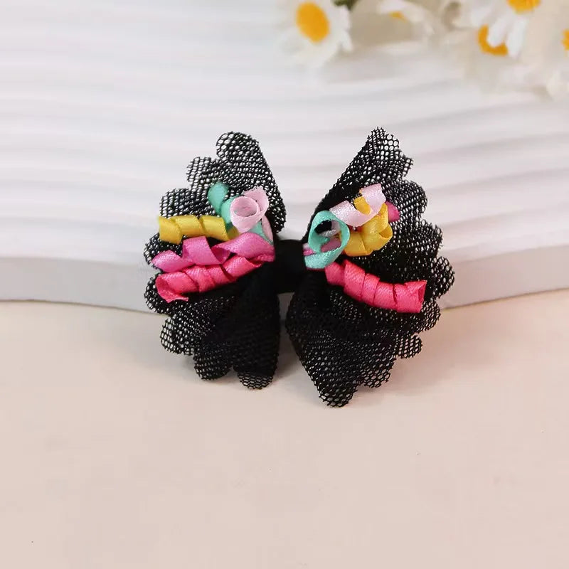 A pair of elegant black lace dog hairbows featuring pink and yellow fabric accents.