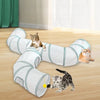 A white and teal collapsible indoor play tunnel for cats lying on a wooden floor.
