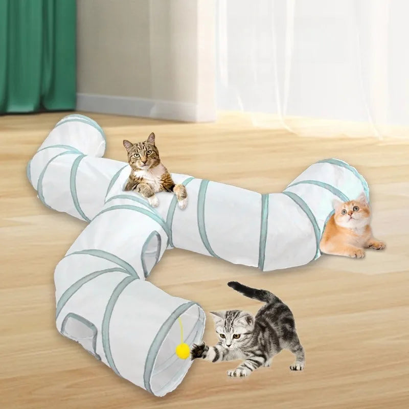 A white and teal collapsible indoor play tunnel for cats lying on a wooden floor.