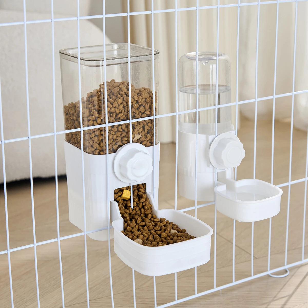 A white automatic pet feeder containing dry food and a separate waterer bowl, viewed through a wire mesh cage.
