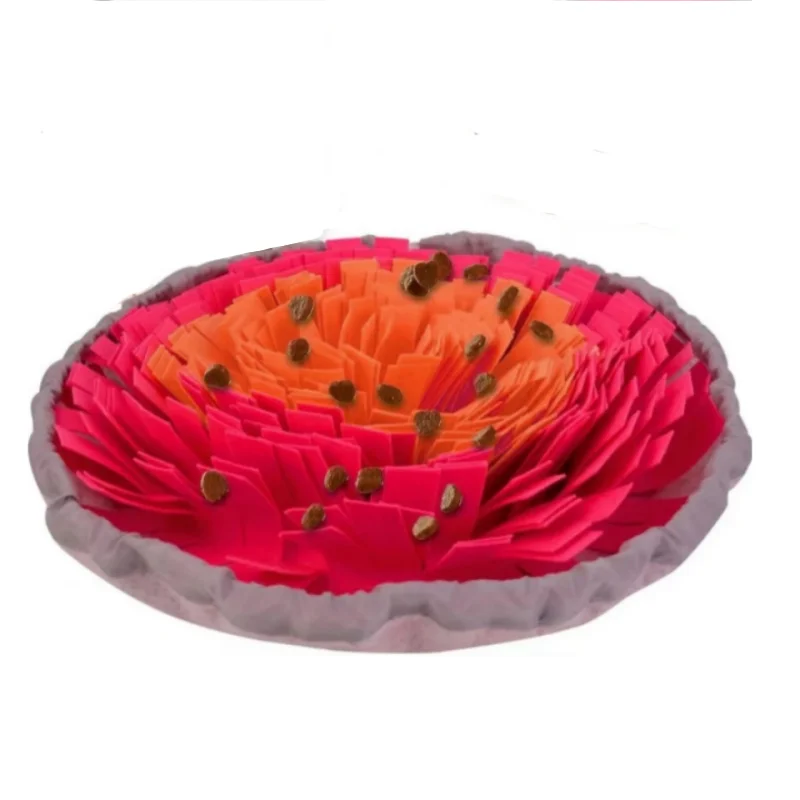 Una estera de fieltro colorida y en capas con flores, pétalos naranja y rosa y pequeños acentos marrones.