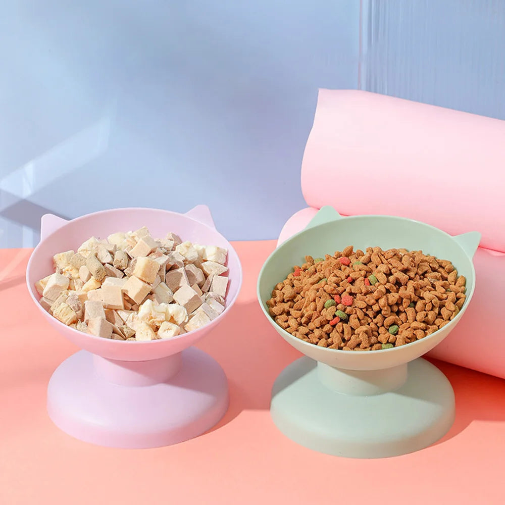 Pink macaron-themed pet food bowl with a non-slip base and a large pink rolled item in the background