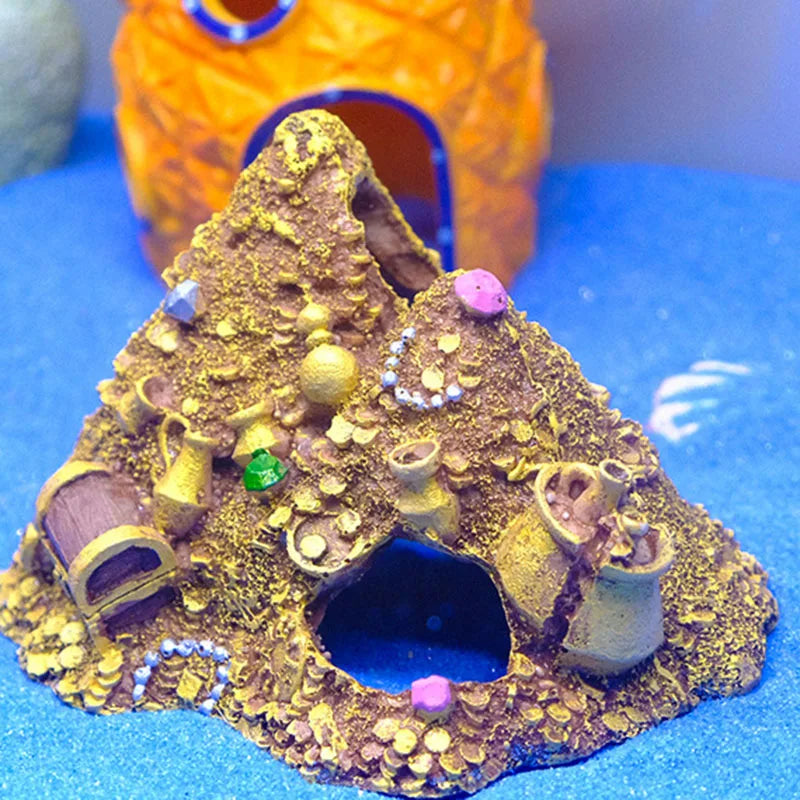 A detailed miniature mountain cave hideout decoration with a treasure chest design featuring gold and brown elements.