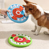 Un chien brun et blanc interagit avec un jouet distributeur à puzzle bleu pour animaux.
