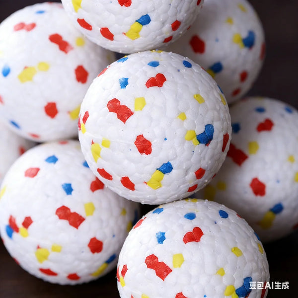 A close-up of several white, speckled dog balls with red, yellow, and blue confetti dots.