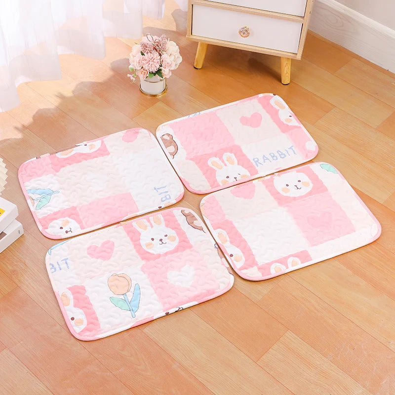 Pink and white soft cotton pet cage mat with a non-slip base placed on a wooden floor.