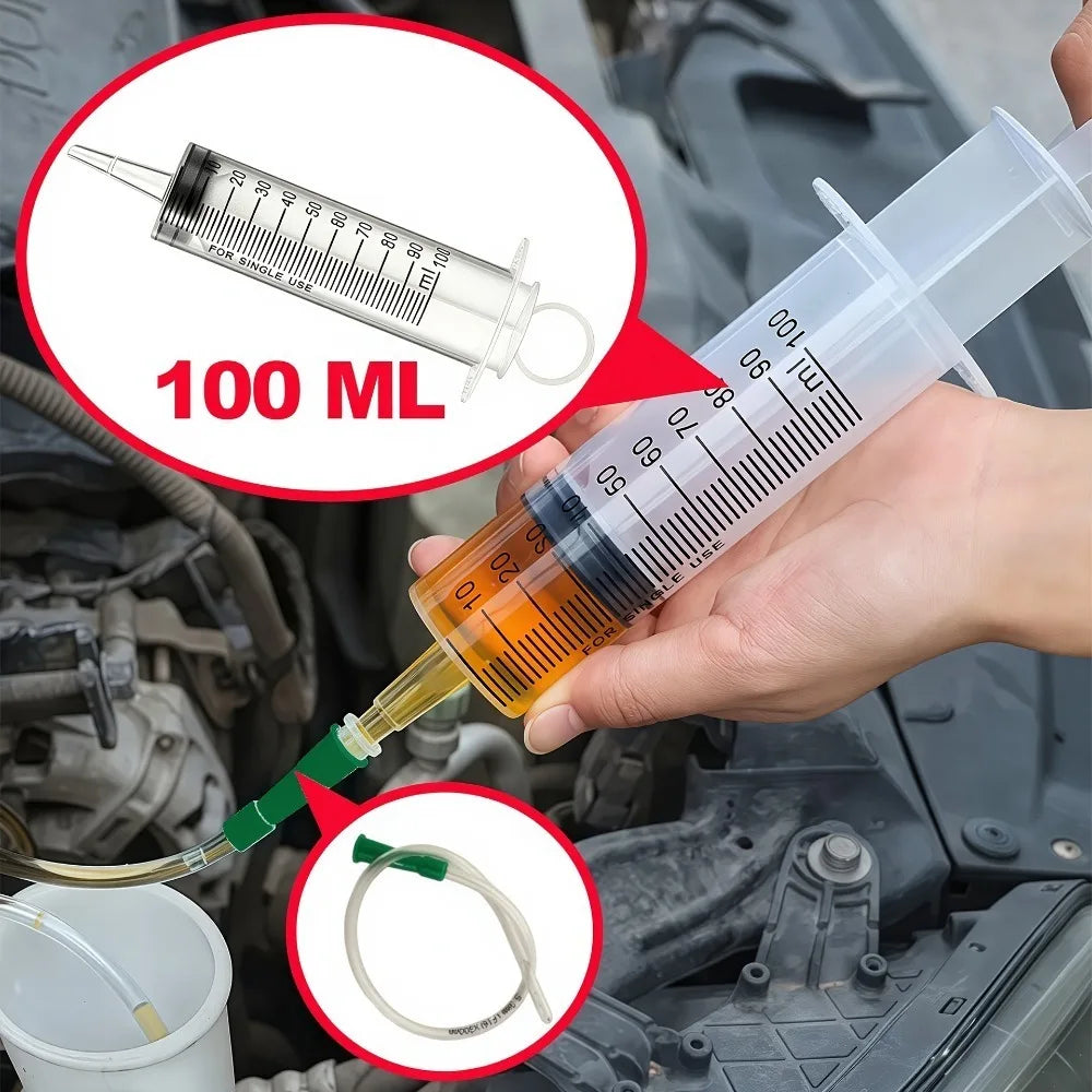 Eine Hand hält eine Plastikspritze mit einer klaren Flüssigkeit, zur Ölextraktion aus einem Motorbauteil.