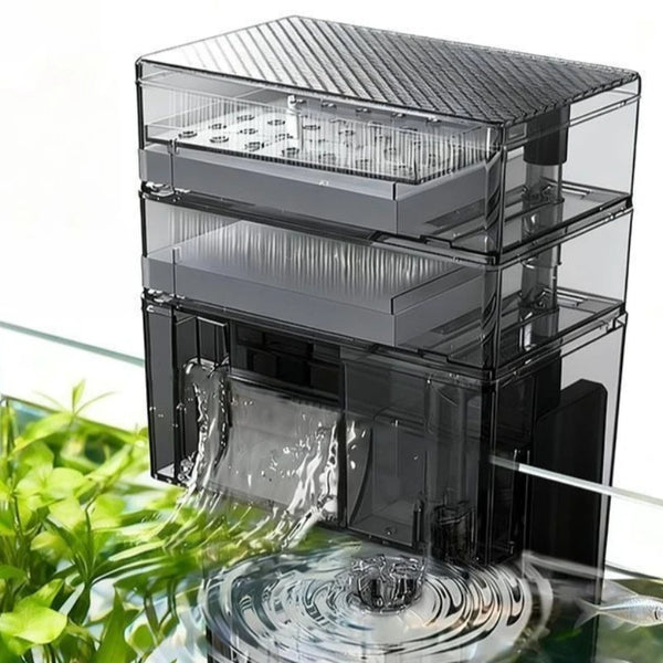 Un sistema de filtración de agua para acuario de varios niveles y transparente, con agua fluyendo a través de él.