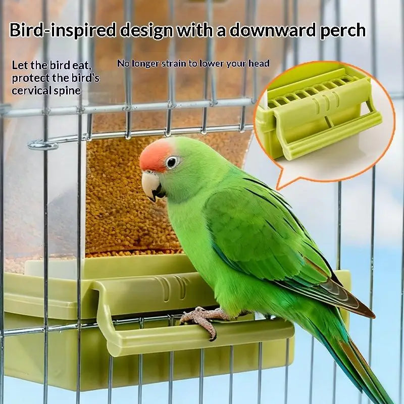A green parrot perches on a downward-sloping perch inside a clear cage feeder.