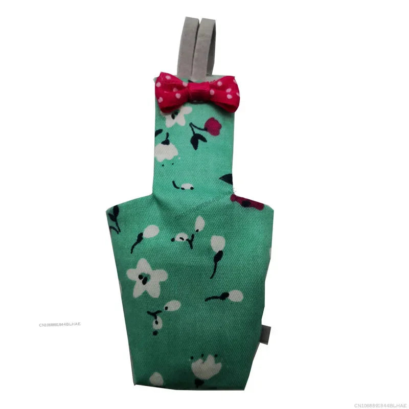 A green shirt featuring a white pattern of birds and a red polka dot bow tie attached to a gray strap.