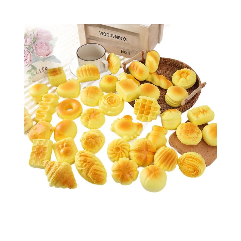 A variety of golden, soft bread-shaped fidget toys are displayed next to a wooden box.
