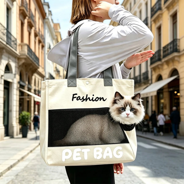 A woman is holding a beige pet bag tote featuring a black silhouette of a cat, walking on a city street.