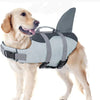 A light-colored dog is wearing a gray life jacket with a fin for swimming.