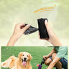 Hände halten einen schwarzen tragbaren Tiermüllsack und einen Golden Retriever auf grünem Gras.