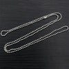 A set of gold and silver plated ball necklaces laid diagonally on a dark surface.