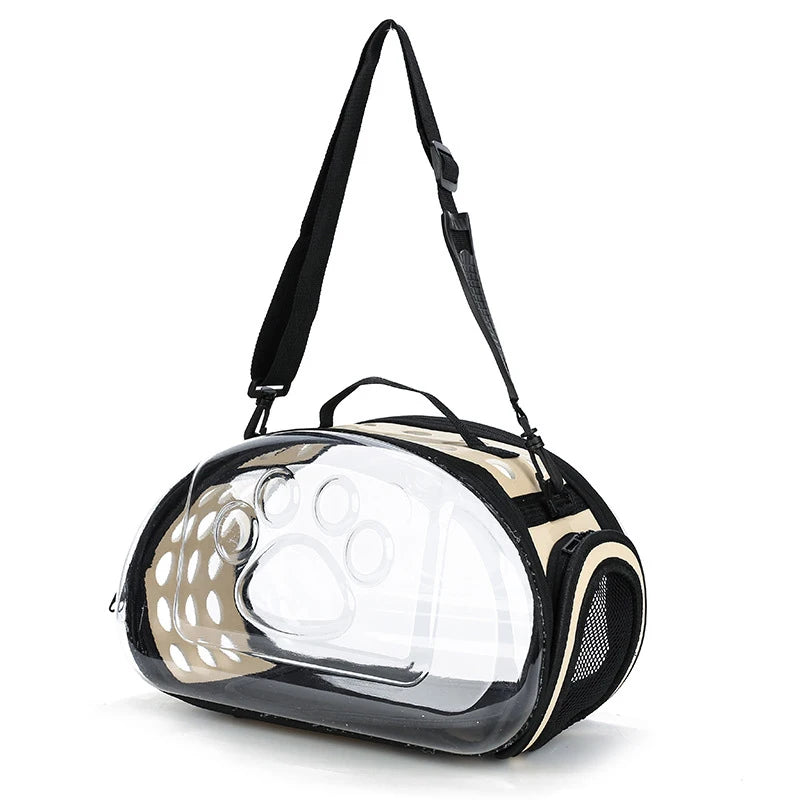 A transparent foldable pet travel carrier with a black shoulder strap, featuring a beige and black design.