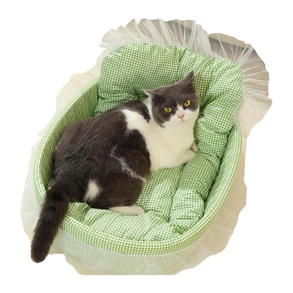 A black and white cat is resting in a green plaid plush pet sofa bed lined with sheer fabric.