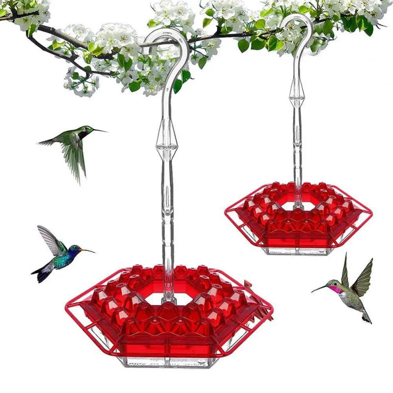 A hummingbird feeder with a hanging hook and a red, hexagonal feeding tray surrounded by white flowers.