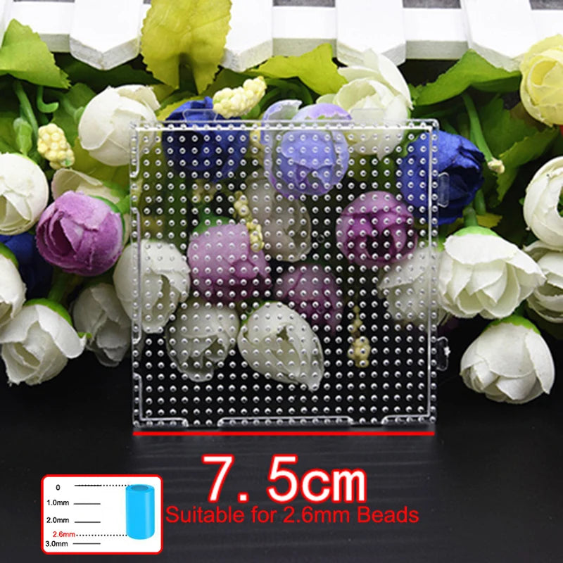 A tray of various colored and white flower-shaped beads is shown next to a precision grid for tweezers.