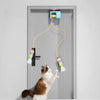 A cat is playing with an automatic electric hanging toy attached to a door.