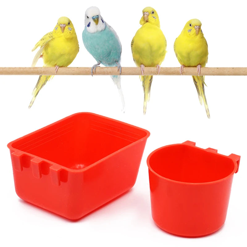 A bright red plastic bird feeder and water bowl with a square tray and a round bowl, shown next to several yellow and blue bi