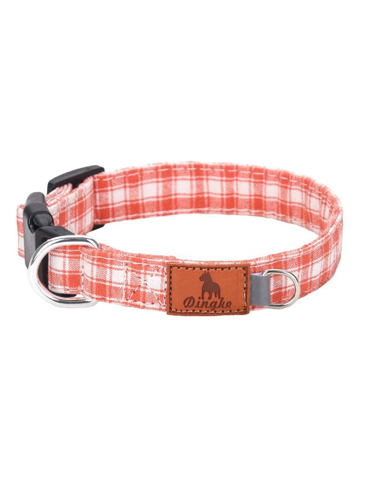 A red and white plaid polyester dog collar with a brown leather tag and silver buckle.
