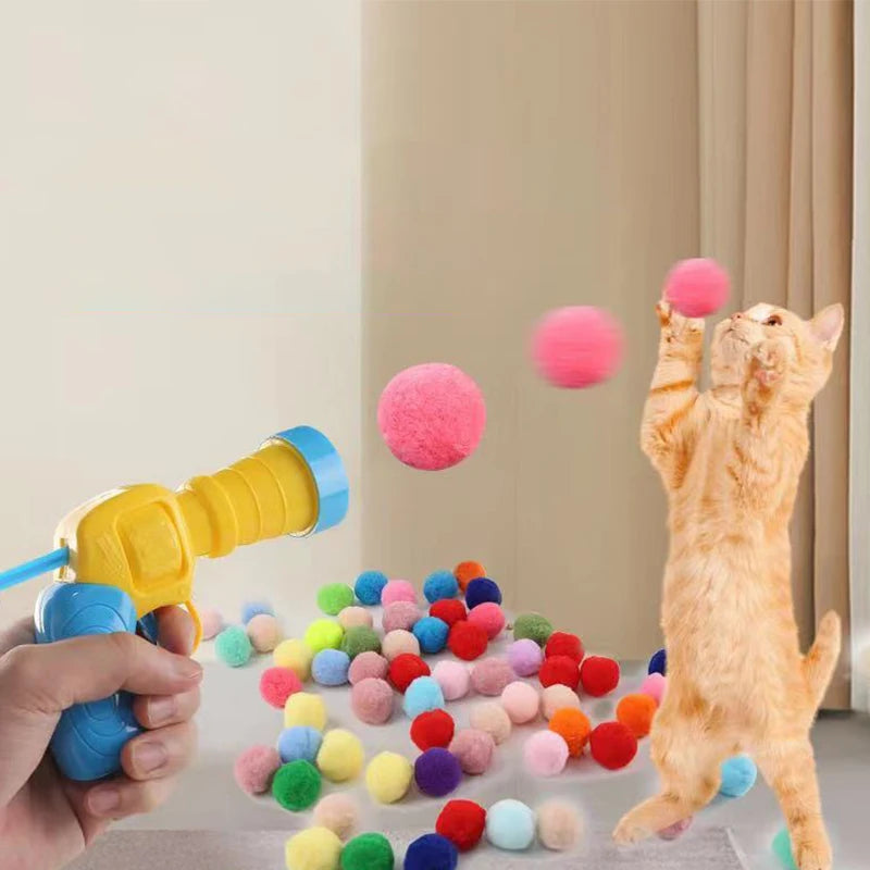 A hand is launching a pink plush ball towards a fluffy orange cat in a light-colored room.