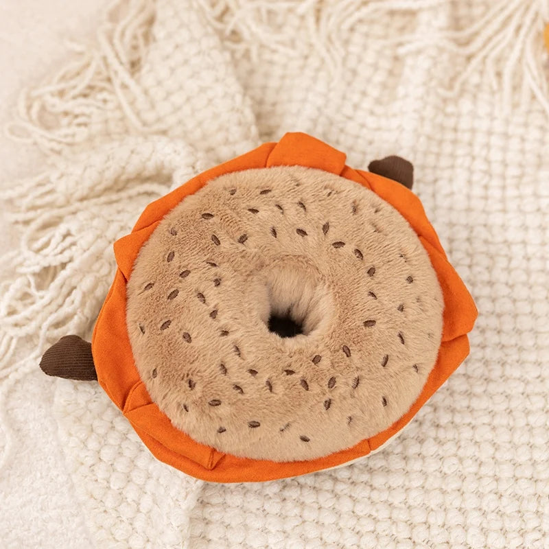 An orange plush toy shaped like a sliced fruit, featuring a light brown textured center.