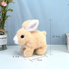 A fluffy, light brown plush bunny toy with white inner ears and pink nose, shown standing on a white surface.