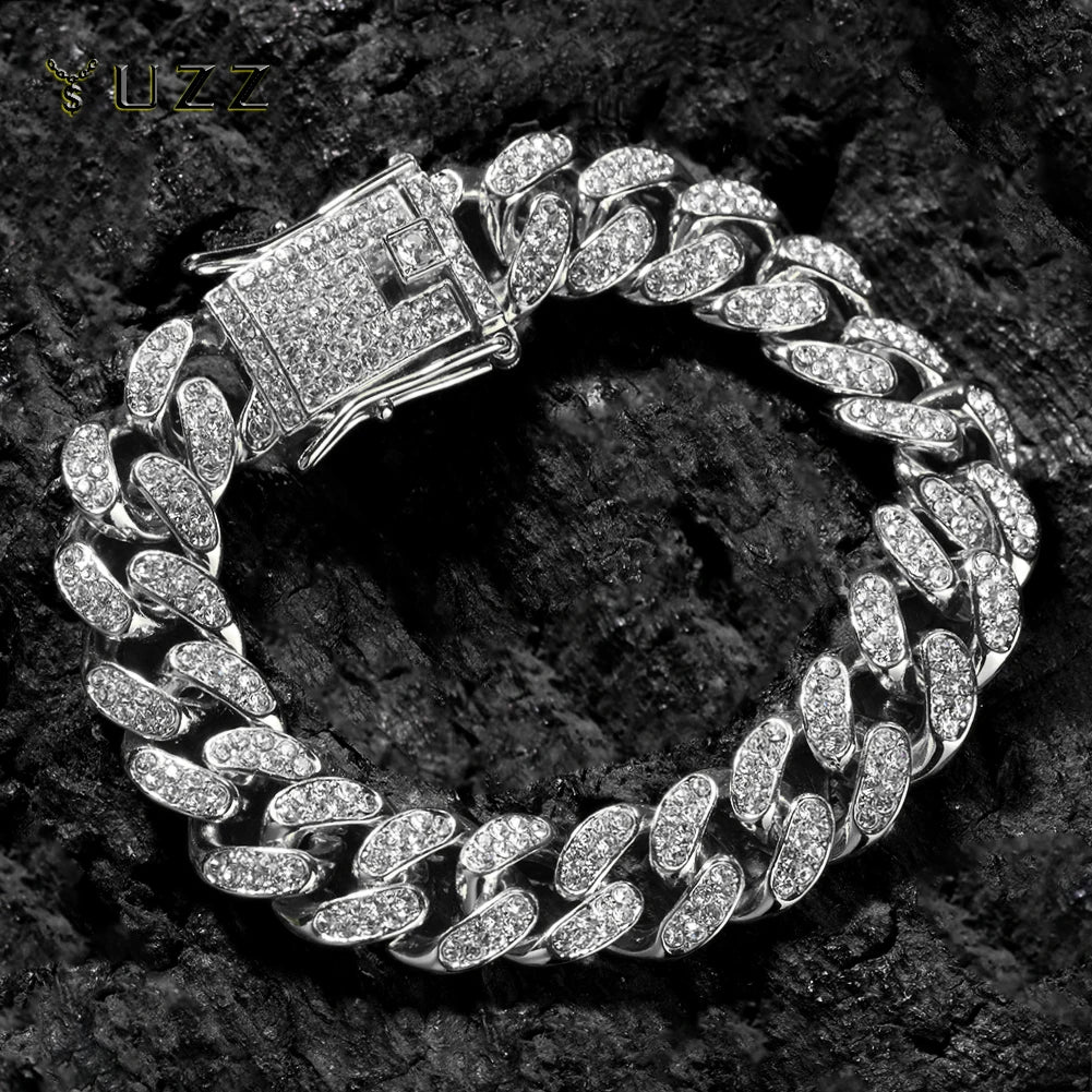Collier statement en maillons cubains argentés avec pendentif rectangulaire, exposé sur une surface sombre et texturée.