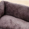 A close-up view of a dark gray, plush dog bed with a soft, textured cover.