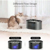 A black automatic cat water fountain with a flowing stream and gentle bubble design placed on a white rug.