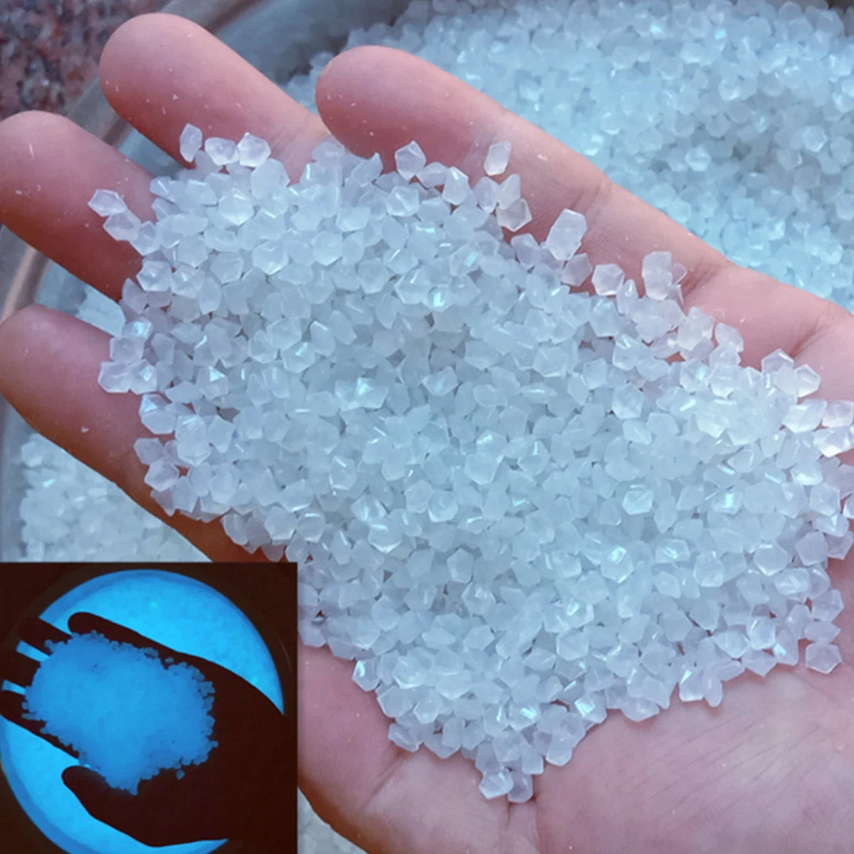 A hand holds a pile of glow-in-the-dark decorative resin pebbles.