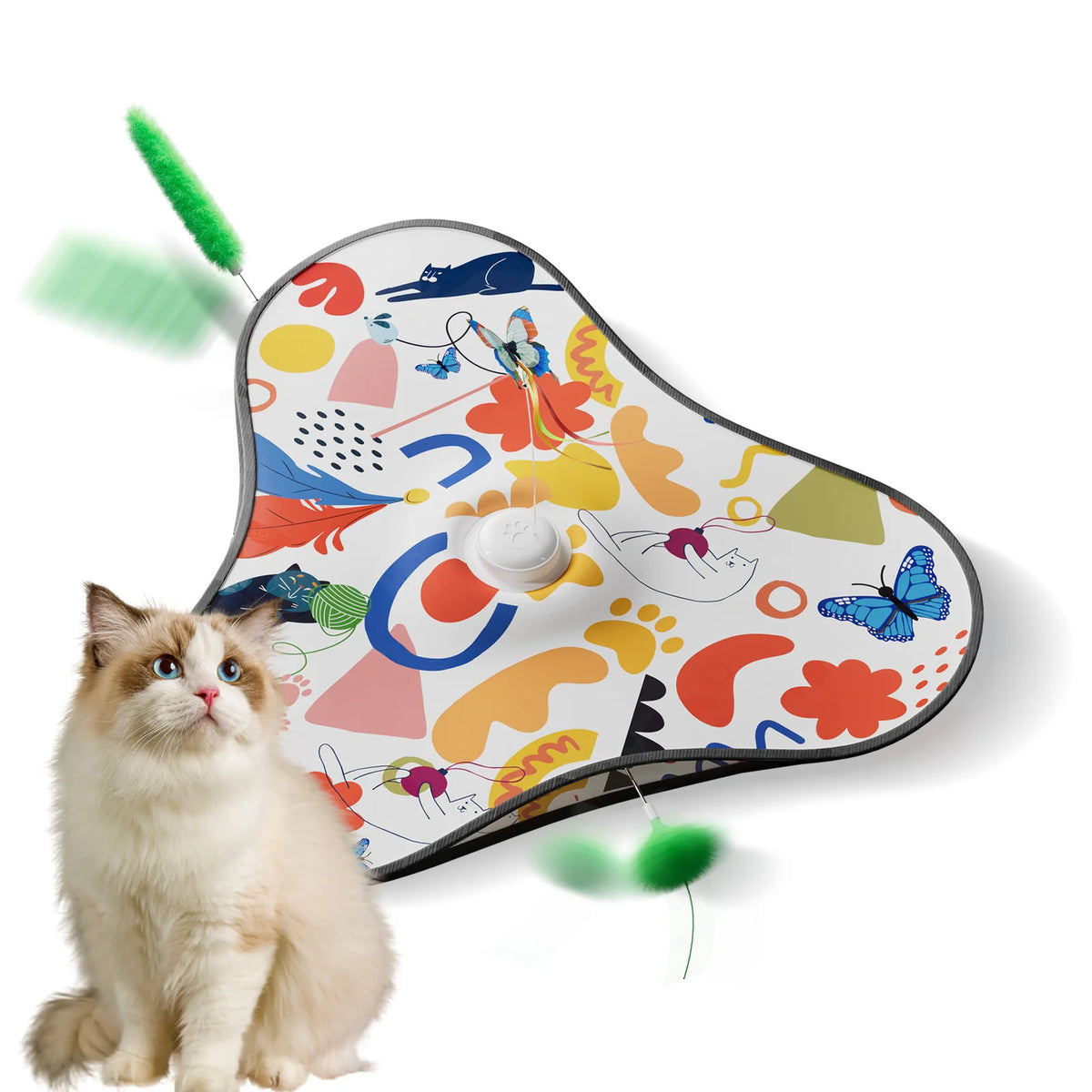 A fluffy ginger cat sits next to an interactive hide and seek toy featuring colorful patterns and motion-activated feathers.